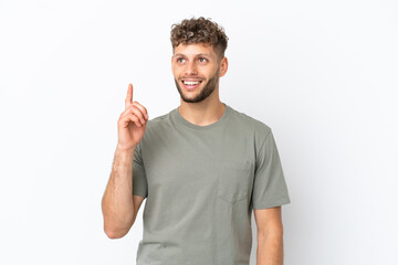 Naklejka premium Young caucasian handsome man isolated on white background pointing up and surprised