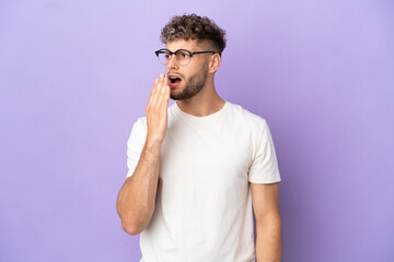 Delivery caucasian man isolated on purple background yawning and covering wide open mouth with hand