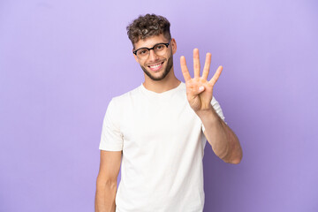 Fototapeta premium Delivery caucasian man isolated on purple background happy and counting four with fingers