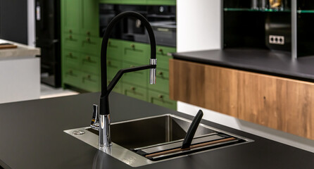 Black faucet with a steel sink in a stylish modern kitchen.