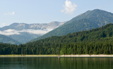 Naklejka premium Standup paddling on bavarian mountain lake, Sylvensteinsteicher