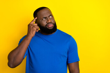 Fototapeta premium Portrait of attractive bewildered guy touching temple overthinking copy space isolated over vivid yellow color background