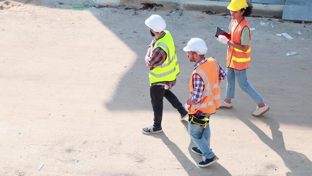 Professional Mechanical Engineer team wearing safety hard hat helmet working in  manufacturing factory under construction site.