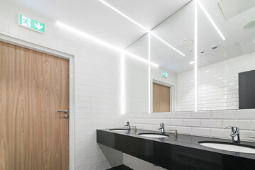 Nowoczesna łazienka z dużym lustrem na całą ścianie. Oświetlenie led sprytnie umieszczone w lustrze - obrazy, fototapety, plakaty