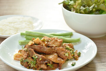 spicy roasted pork Thai salad eat with sticky on plate and fresh vegetable