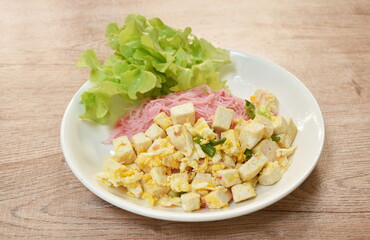 stir fried vermicelli with coconut milk topping slice egg and slice tofu on plate