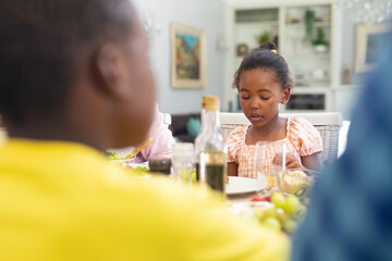 African american girl having lunch with family at home on thanksgiving day