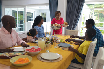 African american having lunch together at dining table on thanksgiving day