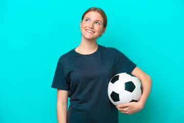 Young football player woman isolated on blue background thinking an idea while looking up