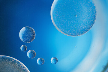 abstract light blue background with oil circles . bubbles of water close up .