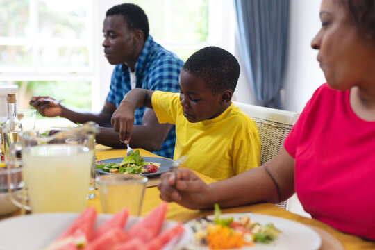 African american boy having lunch with family at home on thanksgiving day