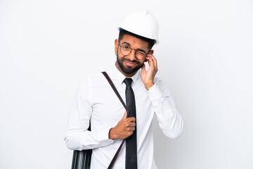 Young architect Brazilian man with helmet and holding blueprints isolated on white background frustrated and covering ears