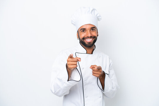 Young Brazilian chef man isolated on white background pointing to the front and smiling