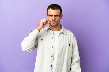 Brazilian man over isolated purple background showing a sign of silence gesture