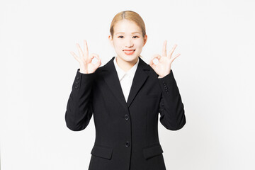 OKのポーズをするジャケットを着た女性