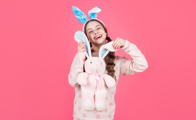 happy easter kid girl in bunny rabbit ears and pajamas play with toy, happy easter