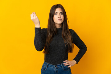 Teenager Brazilian girl isolated on yellow background making Italian gesture