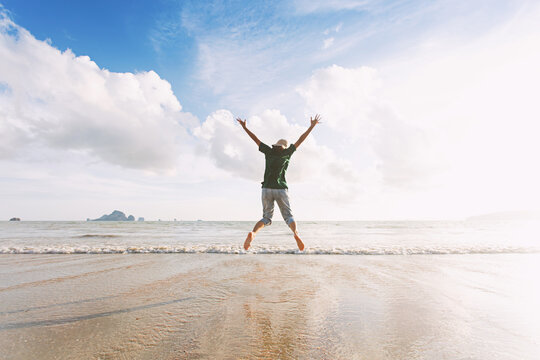 Teenage girl jumping on the beach in the daytime The concept image represents a vacation.