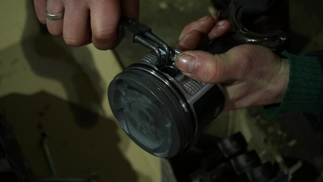 assembling a car engine installing piston rings on a piston