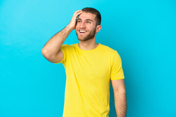 Young handsome caucasian man isolated on blue background smiling a lot