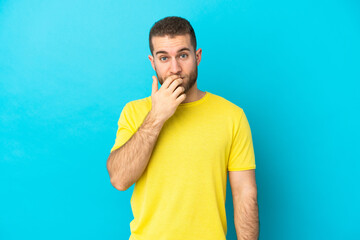 Young handsome caucasian man isolated on blue background surprised and shocked while looking right