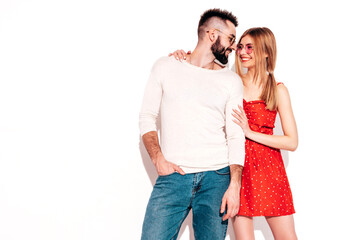 Naklejka premium Sexy smiling beautiful woman and her handsome boyfriend. Happy cheerful family having tender moments near wall in studio.Pure cheerful models hugging.Embracing each other. Cheerful and happy