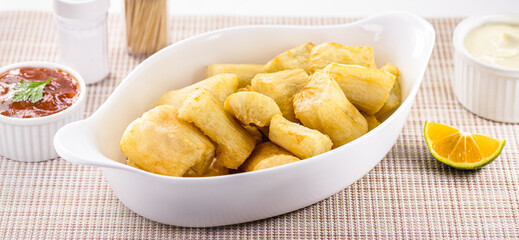 portion of fried cassava in white glass bowl, typical Brazilian food, fried cassava root served hot