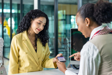 Caucasian passenger show online qr code using mobile phone and passport to the airline ground crew at the check-in counter for verification to get boarding pass for airplane travel and transportation