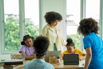 Elementary school,African American school children studying together using tablet device in classroom,Technologies for education concept.