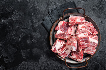 Raw diced beef and lamb marbled meat in kitchen steel tray. Black background. Top view. Copy space