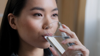 Close up asian woman drinking clean water home delivery holding glass lunch morning daily ritual good habit girl feels thirsty health care hydration dehydration refreshment drink smiling feeling good