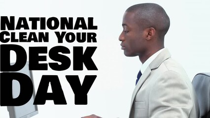 Animation of national clean your desk day text over african american businessman using computer