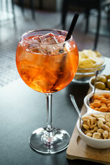 Spritz cocktail aperitif with Italian appetizers on an outdoors bar table