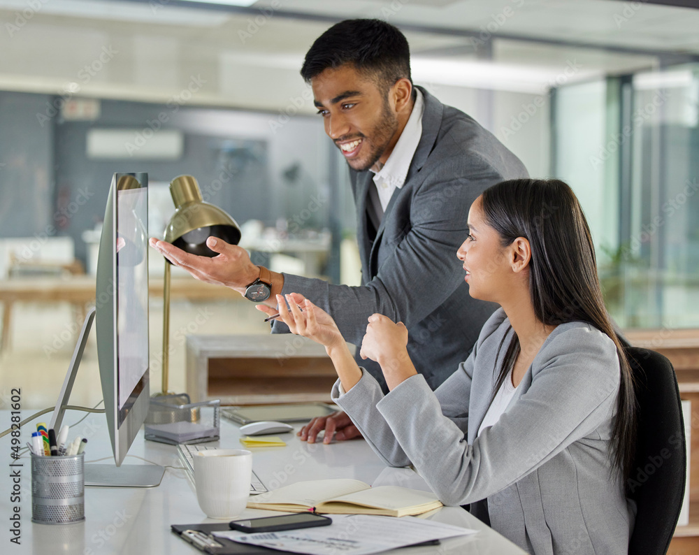 Aufkleber Getting it done with the power of one. Shot of a young businessman and businesswoman using a computer in a modern office.