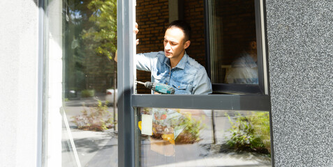 Construction worker installing window in house