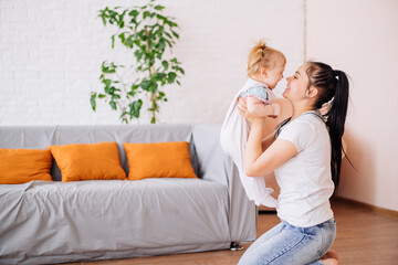 a little girl takes her first steps at home from the sofa towards her mother. the concept of a healthy child