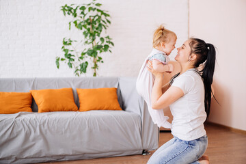 a little girl takes her first steps at home from the sofa towards her mother. the concept of a...