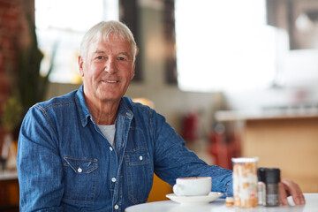 Kickstarting my day with coffee. Portrait of a relaxed senior man enjoying a cup of coffee in a coffee shop.