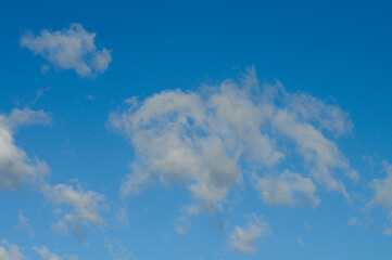 A blue sky with soft white clouds