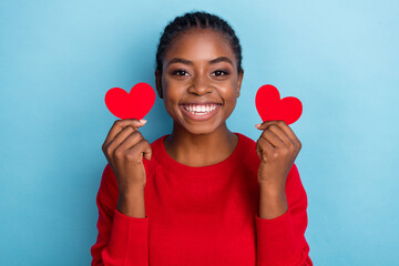 Photo of impressed millennial brunette lady hold hearts wear red pullover isolated on blue color background