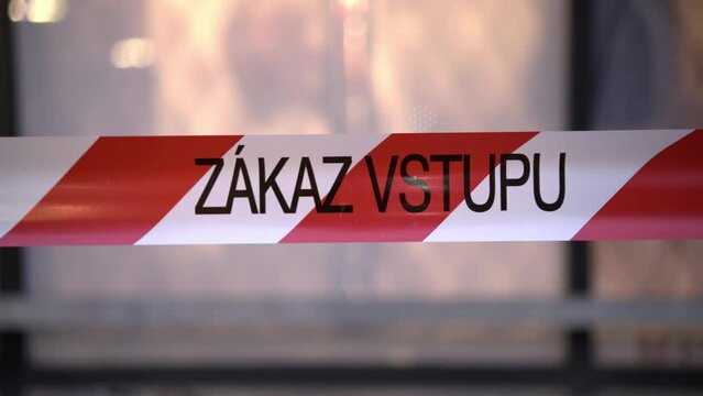 Czech inscription Zakaz vstupu written on red and white ribbon meaning No entrance. Warning sign Entry denied on blurred background in city closeup