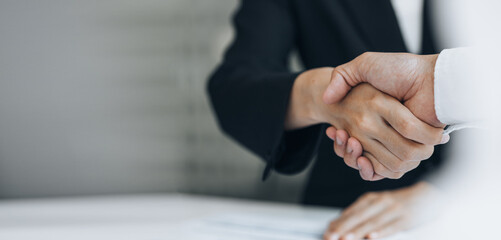 Close-up two business men holding hands, Two businessmen are agreeing on business together and shaking hands after a successful negotiation. Handshaking is a Western greeting or congratulation.
