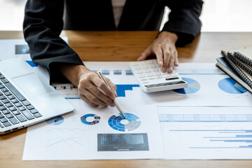 Business woman checking financial documents, she owns a startup company, she sits checking the company's financial summary prepared by the finance department. Management concept of startup company.