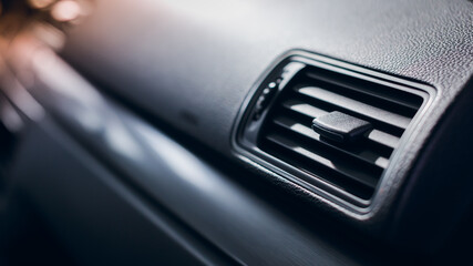 Air vent grill and air conditioning in modern car interior.