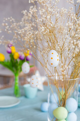 Table with Easter decor in soft pastel colors with branches of white gypsophila. - 498287895