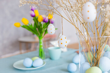 Table with Easter decor in soft pastel colors with flowers. - 498287899