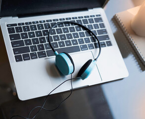 Obraz na płótnie Canvas Blue headphone put on blurred laptop,