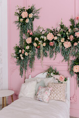 A baby bed decorated with flowers, pillows neatly folded. Close-up