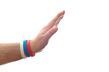 A hand outstretched in a gesture of denial or refusal on a white background. Bracelet in the colors...