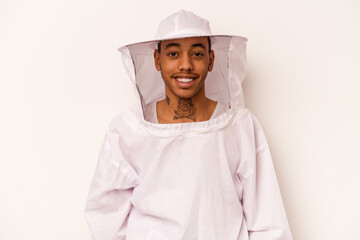 Young African American beekeeper isolated on white background happy, smiling and cheerful.